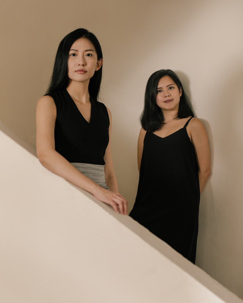 Ellison Tan and Myra Loke standing along a stairwell.